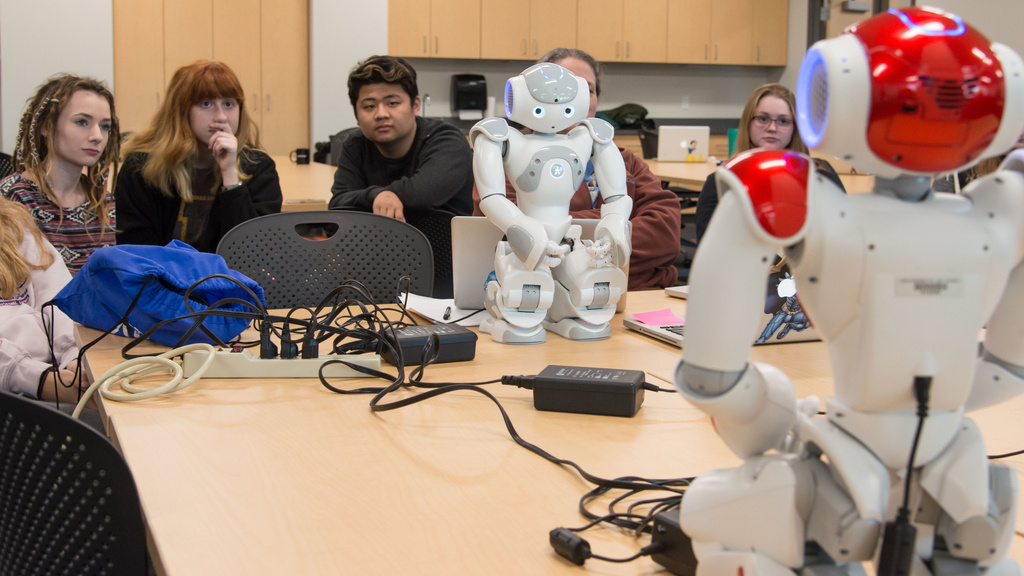 High school students operate robots as part of a STEM learning activity.