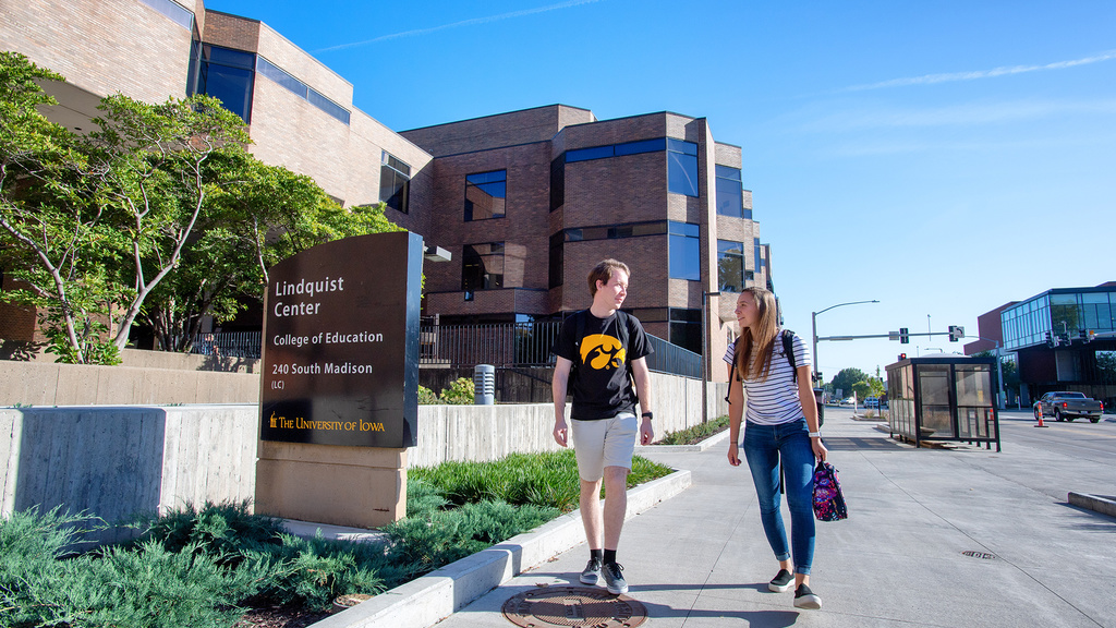 two students walk near Lindquist Center on a sunny day