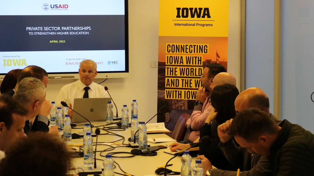 College of Education Dean Daniel L. Clay sits at the head of a conference table, leading a workshop with industry experts in Kosovo.