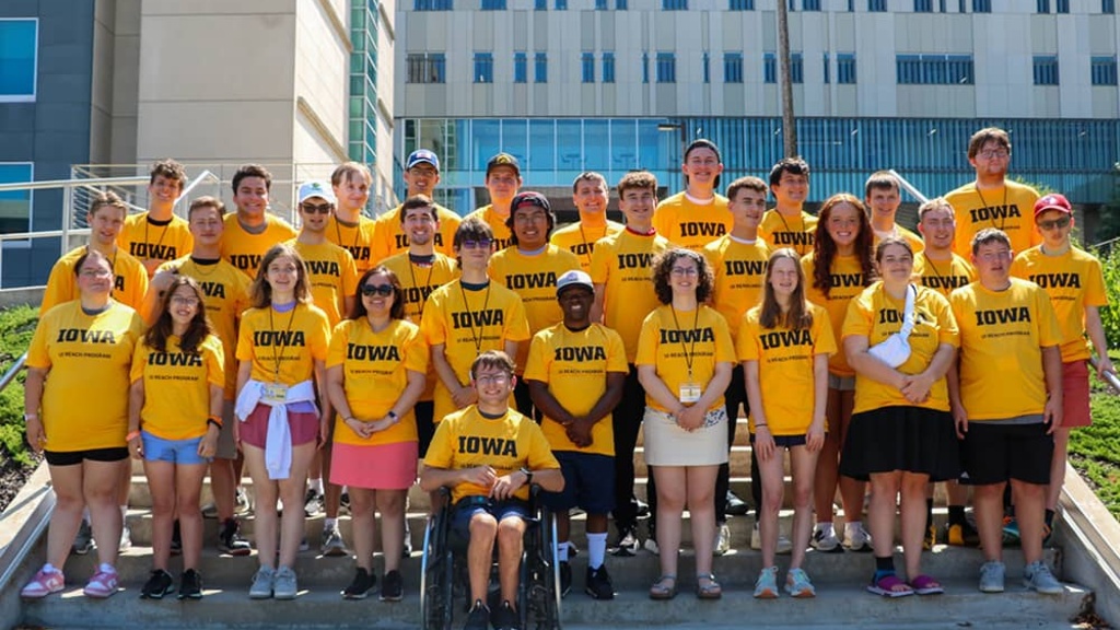 New UI REACH students stand together wearing matching UI REACH shirts.