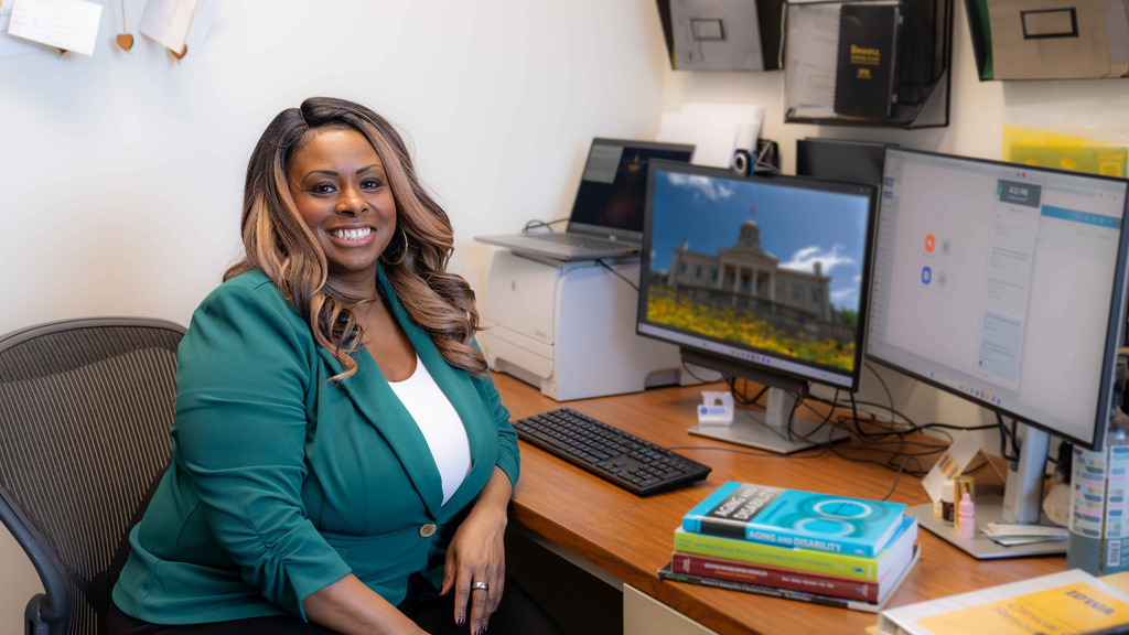 Black woman professor smiles in front of computer